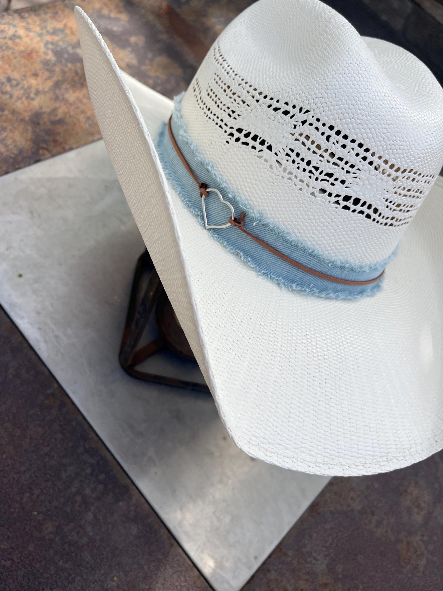 western cowboy hard straw hat with a light blue denim band.