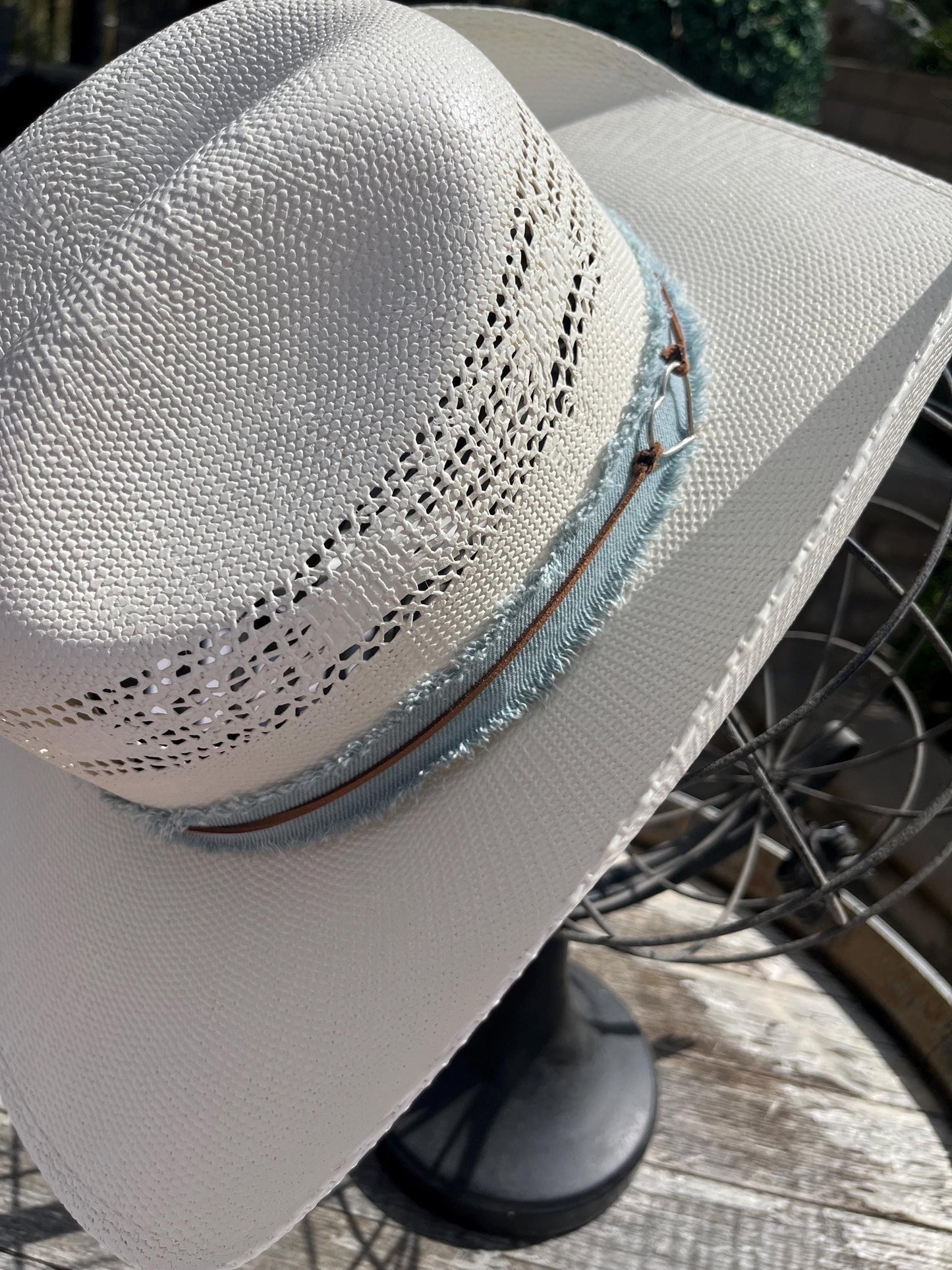 western cowboy hard straw hat with a light blue denim band.