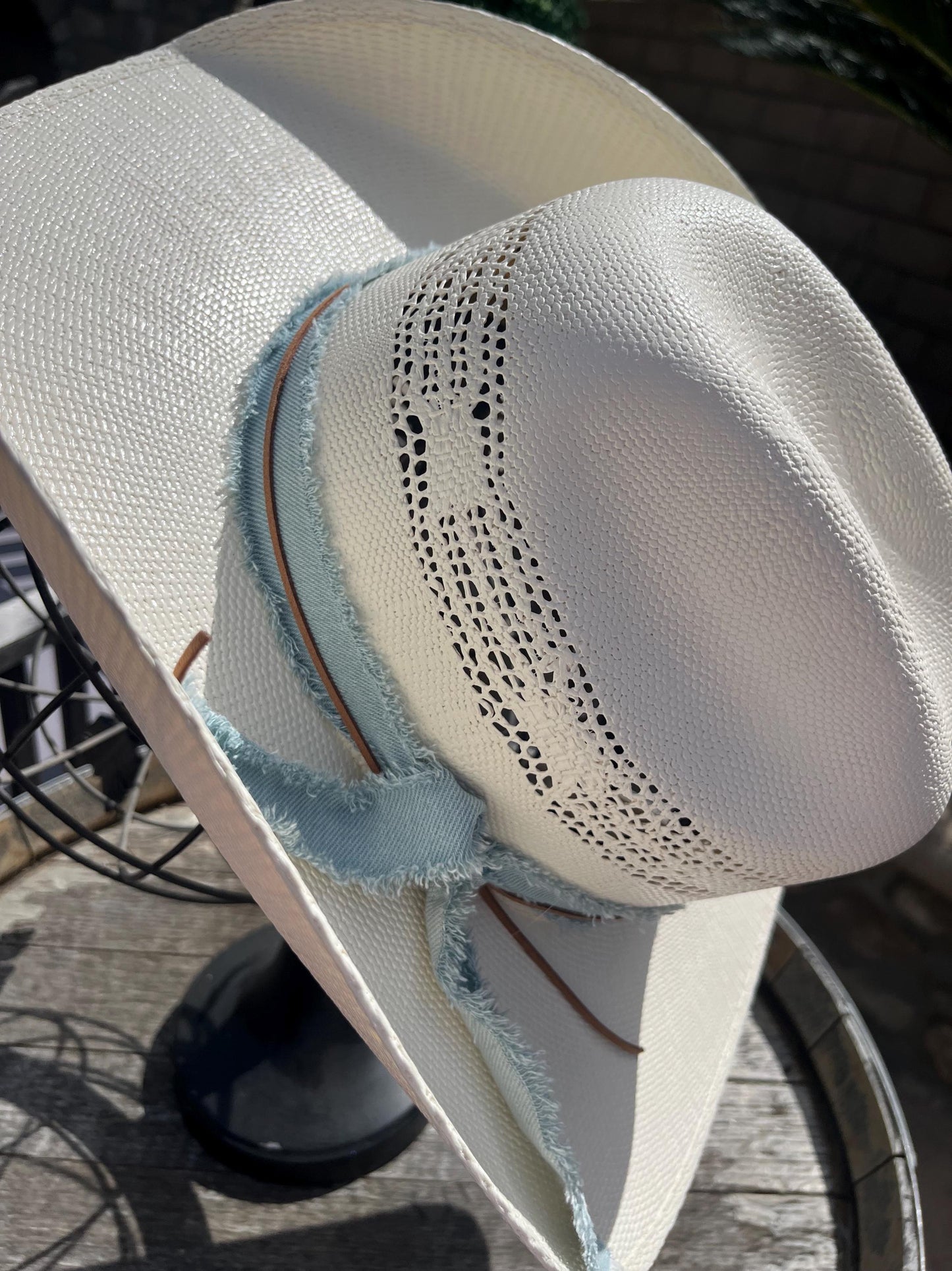 western cowboy hard straw hat with a light blue denim band.