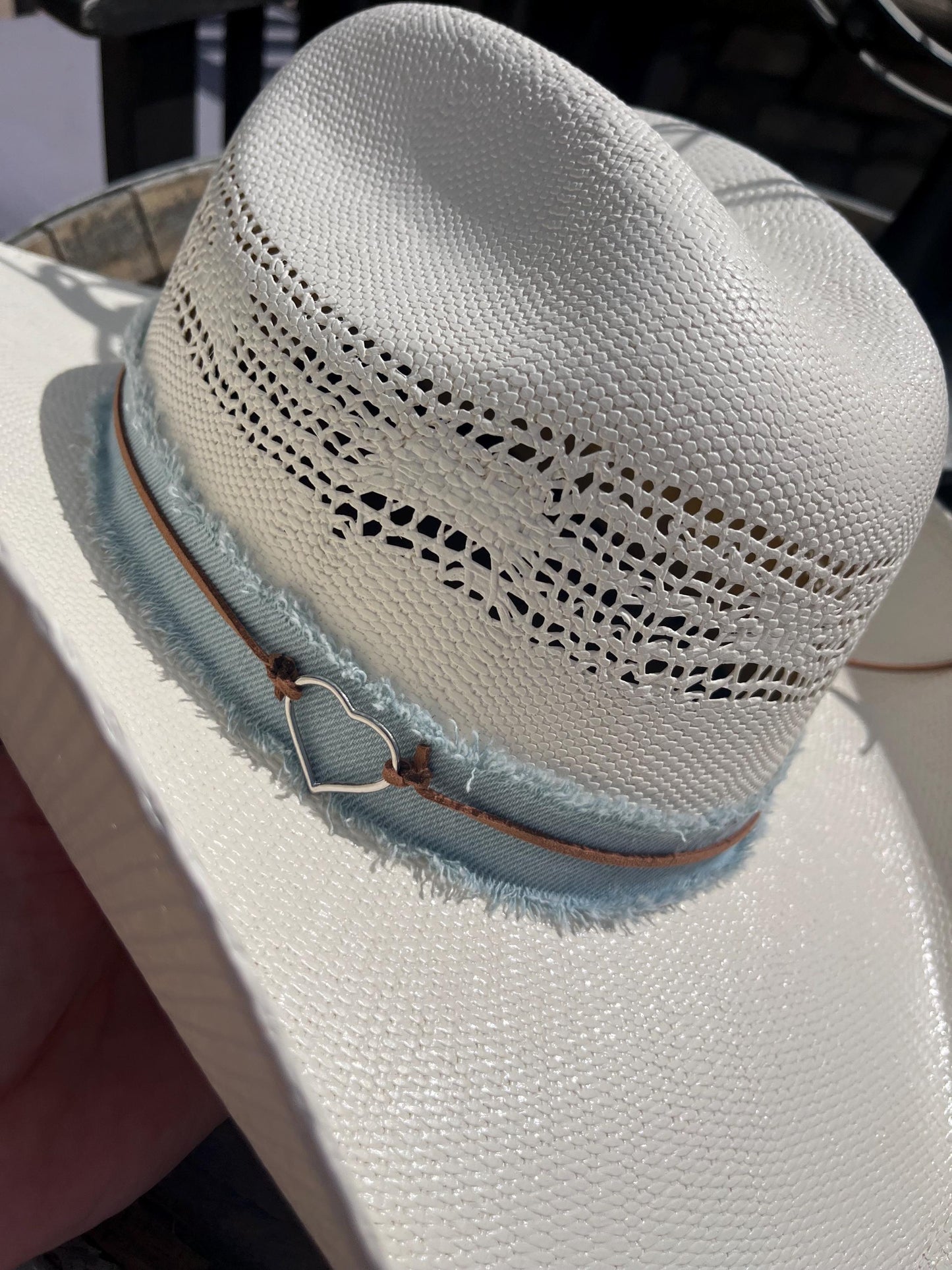western cowboy hard straw hat with a light blue denim band.