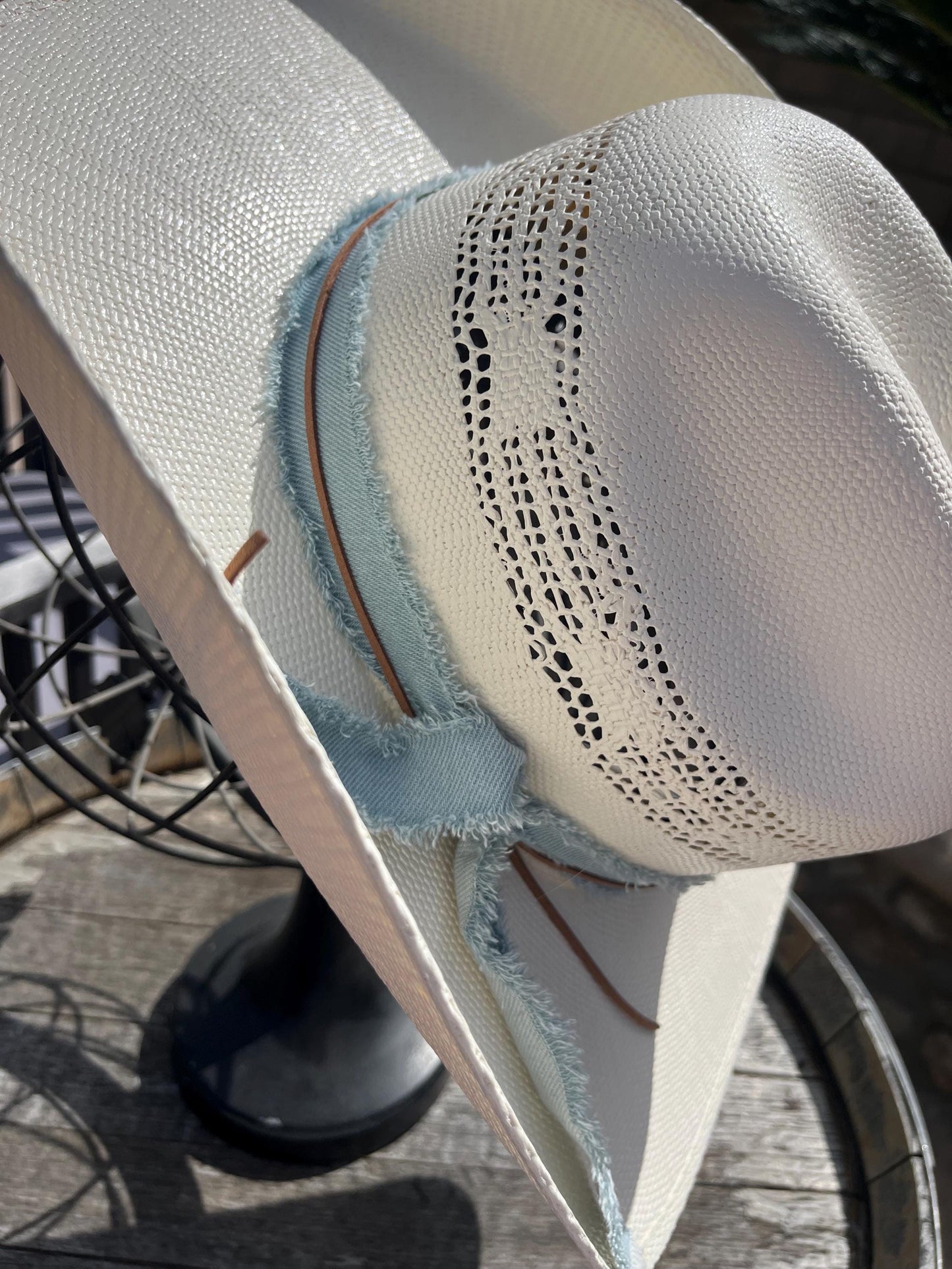 western cowboy hard straw hat with a light blue denim band.