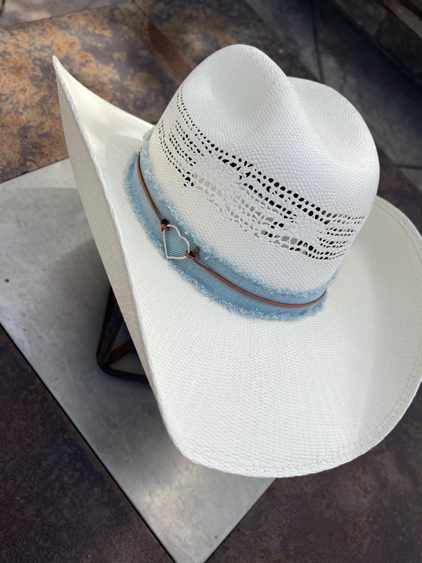 western cowboy hard straw hat with a light blue denim band.